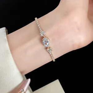 Detailansicht eines eleganten Goldarmbandes mit ovalem Zirkon und Blumenanhänger