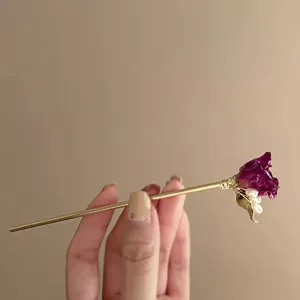 Gros plan d'une épingle à cheveux de style chinois avec rose pourpre et perles