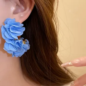 Close-up view of elegant blue chiffon flower C-shaped earrings for beach vacation style