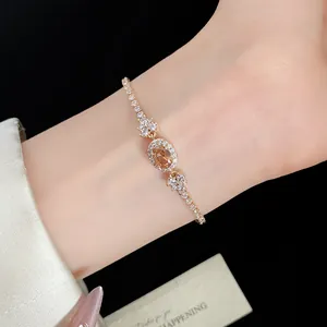 Nahaufnahme eines eleganten Goldarmbandes mit champagnerfarbenem Zirkon am Handgelenk