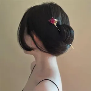 Vue détaillée d'un modèle portant une épingle à cheveux rose séchée dans un chignon