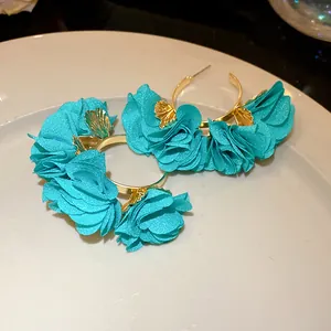 Detailed view of turquoise chiffon flower C-shaped hoop earrings with gold accents
