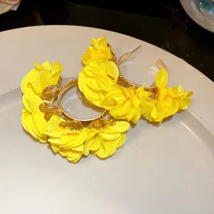 Detailed view of yellow chiffon flower C-shaped hoop earrings for a beach vacation style