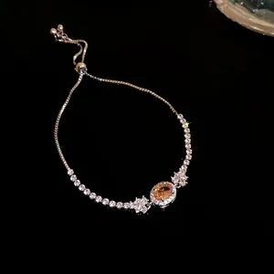 Detailansicht eines luxuriösen silbernen Armbands mit funkelndem orangefarbenem Zirkon