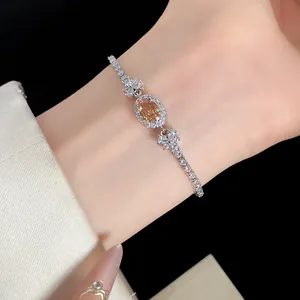 Elegantes silbernes Zirkonia-Armband mit ovalem champagnerfarbenem Stein am Handgelenk.