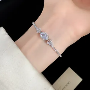 Nahaufnahme eines silbernen Armbands mit funkelndem ovalem Zirkonia-Anhänger am Handgelenk