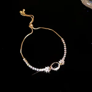 Detailansicht eines eleganten goldenen Armbands mit blauem Stein und Zirkonia.