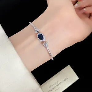 Nahaufnahme eines eleganten blauen Zirkon-Armbands mit Silberkette am Handgelenk.