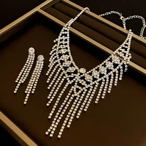 Dettaglio di elegante set collana e orecchini con nappe di strass a fiori su vassoio