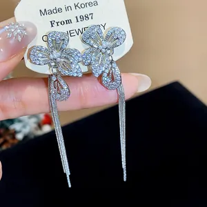 Dettaglio di orecchini a fiore in argento con zirconi e eleganti nappe pendenti