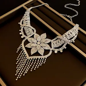 Dettaglio della collana a fiore argento con cuore di strass e lunghe nappe lucide