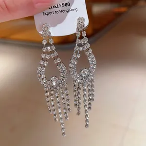 Primo piano di eleganti orecchini a pendente con nappe argentate e strass brillanti