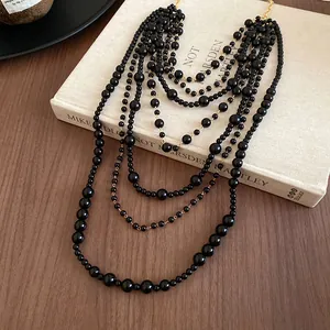 Detail of multi-layered vintage black acrylic beaded long sweater chain necklace.