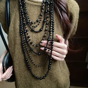 Close-up of a stylish multi-layered black beaded sweater necklace for women in autumn and winter