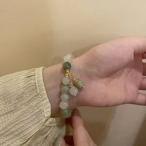 Nahaufnahme eines handgefertigten Perlenarmbands mit grünen Perlen an einem Handgelenk