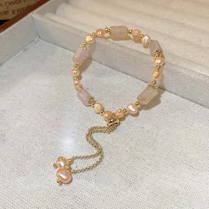Detailansicht eines handgefertigten Armbands mit rosa Perlen und Rosenquarzsteinen.