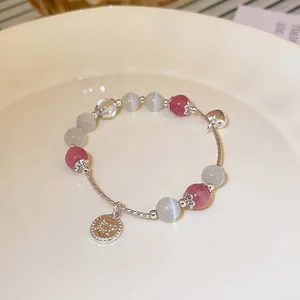 Detailansicht eines handgefertigten Perlenarmbandes mit feinen silbernen Anhängern