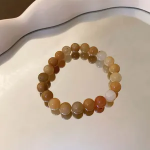Detaillierte Nahaufnahme eines handgefertigten Perlenarmbands auf einem Wellenspiegel