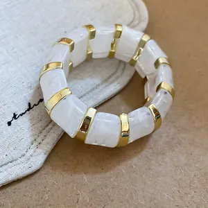 Elegant white marbled acrylic stretch bracelet with gold-tone spacers for a modern look