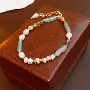Nahaufnahme eines handgefertigten Perlenarmbands mit Perlen und grünen Jade-Kugeln
