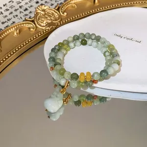 Nahaufnahme eines handgefertigten Perlenarmbands im Jade-Stil mit kleinem Fuchs-Anhänger