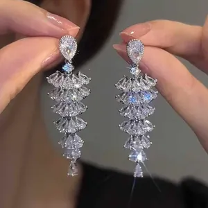Detailed close-up of sparkling silver drop earrings with multi-layered teardrop zircons