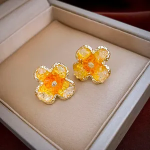 Detailansicht der eleganten gelben und klaren Kristallblumen-Ohrstecker in Schmuckbox