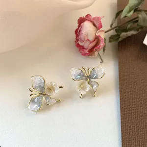 Detailansicht der eleganten Kristall-Schmetterlingsohrringe mit Perlenblumen-Akzenten