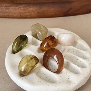 Detailed close-up of retro resin geometric rings in assorted earth tones on a display