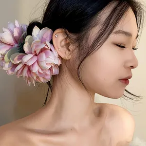Dettaglio di una raffinata molletta per capelli a forma di fiore rosa per un look fatato e chic.