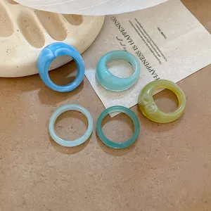 Detailed view of five vintage resin geometric rings in various colors and styles