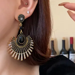 Vintage gold-toned waterdrop tassel earrings with black crystals on model