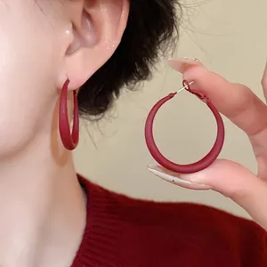 Elegant minimalist matte red geometric hoop earrings with silver needle shown on model