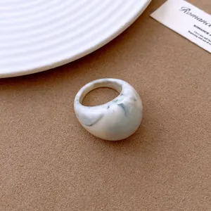 Close-up of vintage white marbled resin ring with chunky geometric dome design