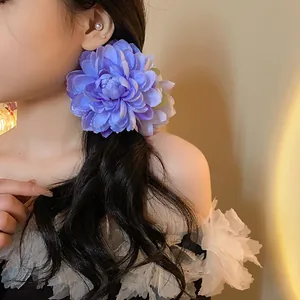 Dettaglio di una grande molletta per capelli a fiore di stoffa viola su capelli lunghi