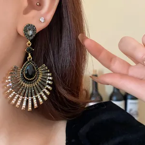 Close-up detail of vintage fan-shaped drop earrings featuring black teardrop crystals