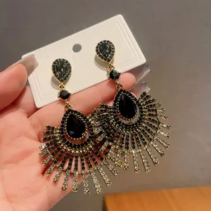 Macro view of teardrop black crystal earrings with fanned rhinestone tassels