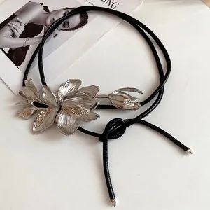 Elegant metallic tulip waist chain with black leather cord for chic vintage fashion.