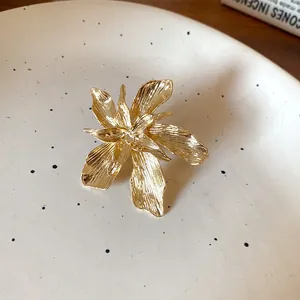 Close-up of a vintage gold-toned floral ring with intricate textured petals on a plate