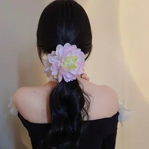 Dettaglio di una grande clip per capelli a fiore rosa su una coda di cavallo nera