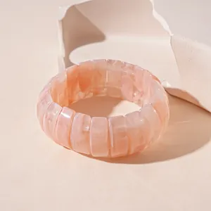 Detailed view of an elegant peach pink marble texture acrylic wavy wide bangle bracelet