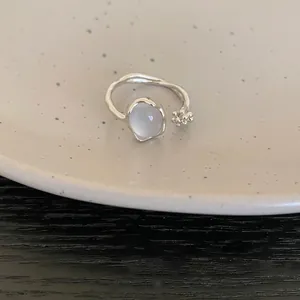 Detailed view of a vintage minimalist silver open ring with a milky resin stone.