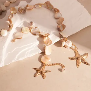 Primo piano di collana stile oceano con conchiglie irregolari e stelle marine.