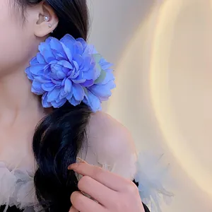 Vista dettagliata di un'elegante clip per capelli a fiore in tessuto blu tra i capelli scuri