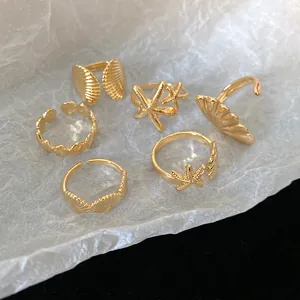 Gold marine theme ring set featuring starfish and shell designs on textured background