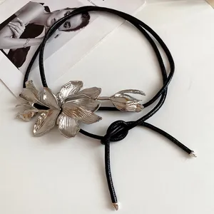 Detailed view of a vintage leather waist chain featuring a metal tulip ornament.
