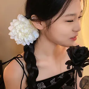 Primo piano di una elegante molletta per capelli a fiore bianco grande in tessuto