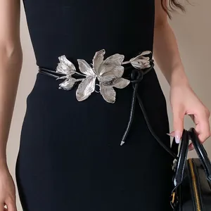 Detail view showing a stunning silver tulip metal ornament on a black leather cord waist chain