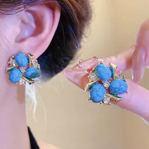 Orecchini vintage dorati con pietre in resina blu e accenti di zirconi trasparenti