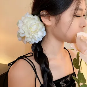 Primo piano di un grande fermaglio per capelli a fiore in tessuto bianco su treccia elegante